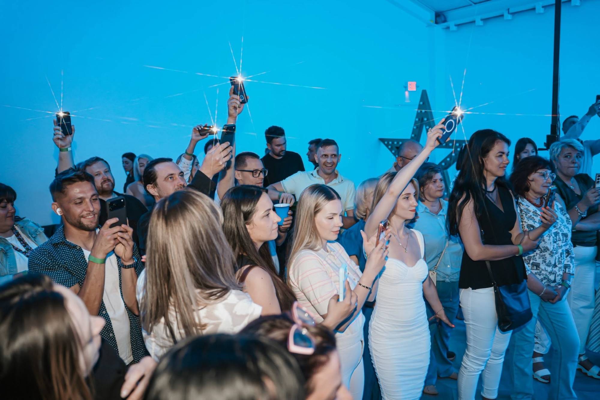Guests lighting up the room with their phones at a live concert at Dream Town